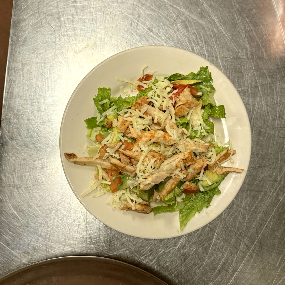 Grilled chicken salad with lettuce, tomato and shredded cheese.